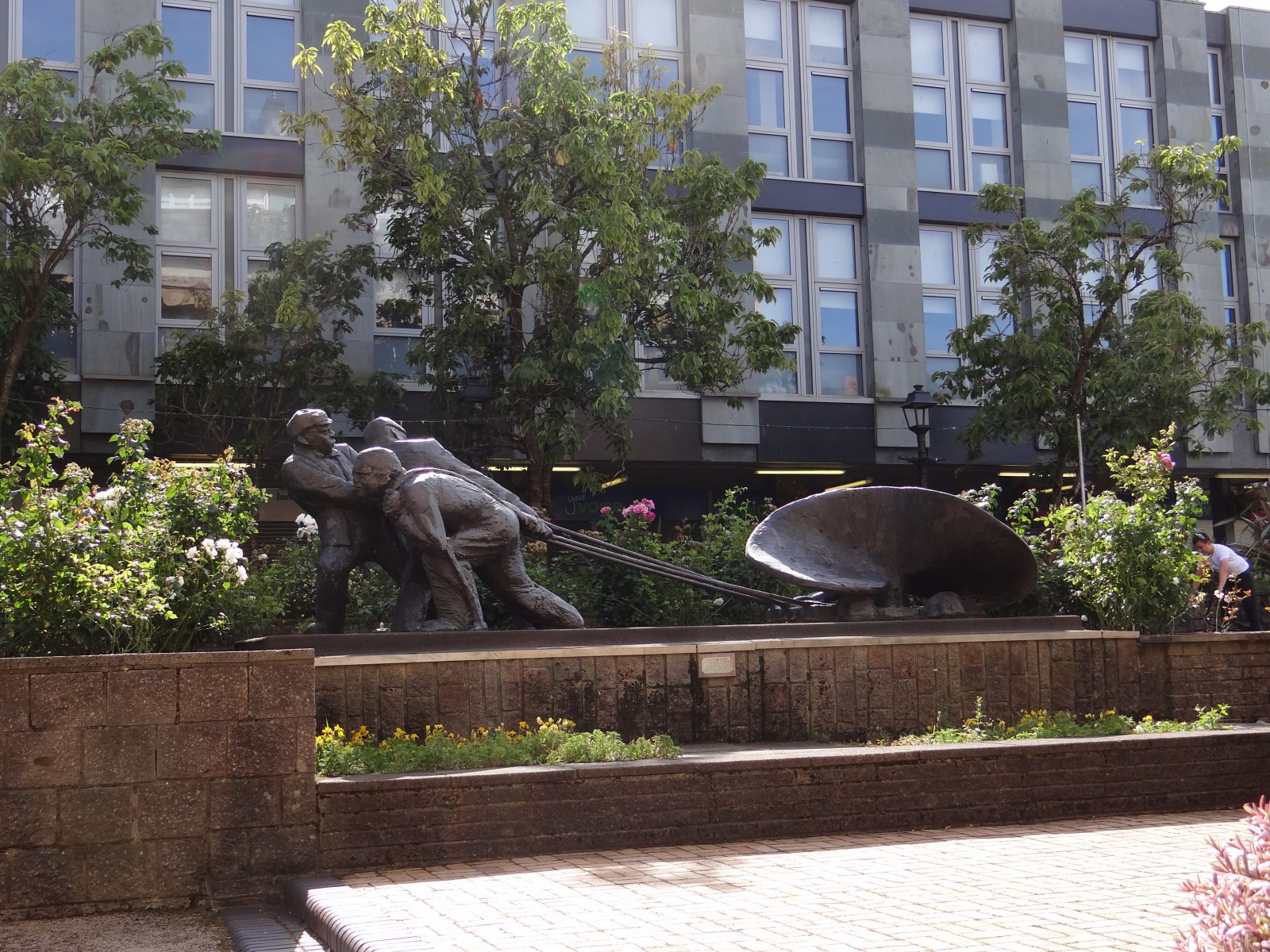 Men of the Clyde –  Clyde Sq.  Designed by Naomi Hunt DA - Sculptor Malcolm Robertson DA -1975   Three men with propeller - ‘This statue represents an industrious Greenock’ Build in remembrance of all who died in local industry.  Service held every year
